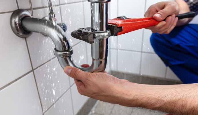 A person is fixing leak pipe with equipment 