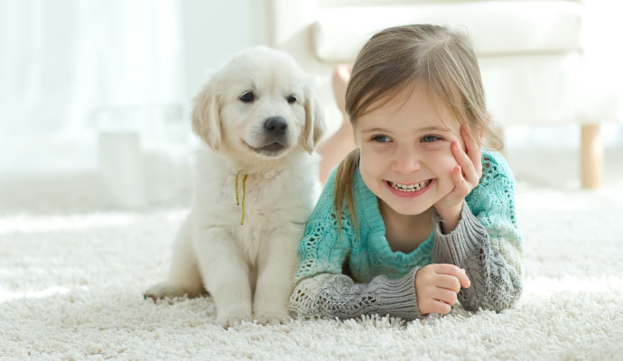 child with puppy On carpet