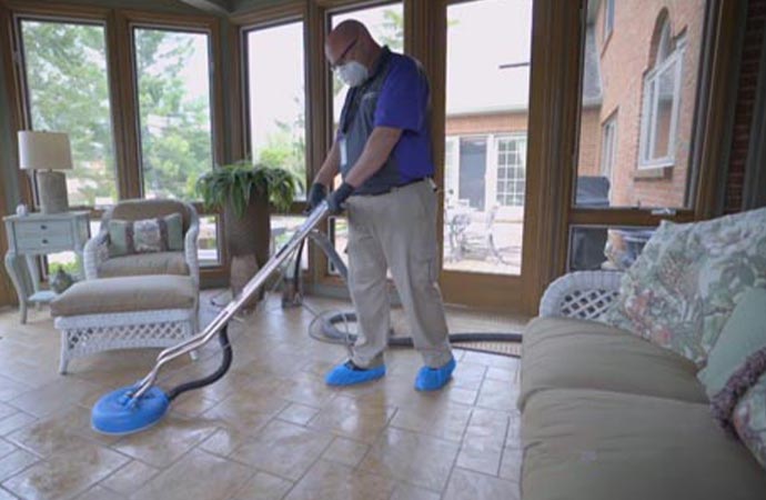 a professional cleaning a floor using equipment