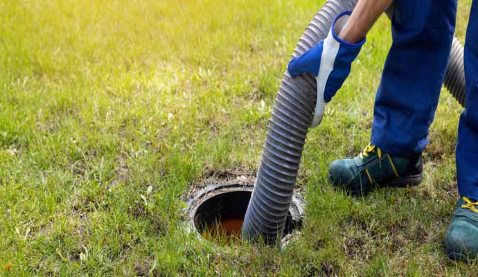 A person is cleaning a septic tank with equipment